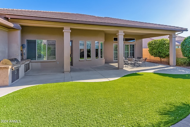 back of house featuring exterior kitchen, a yard, and a patio area