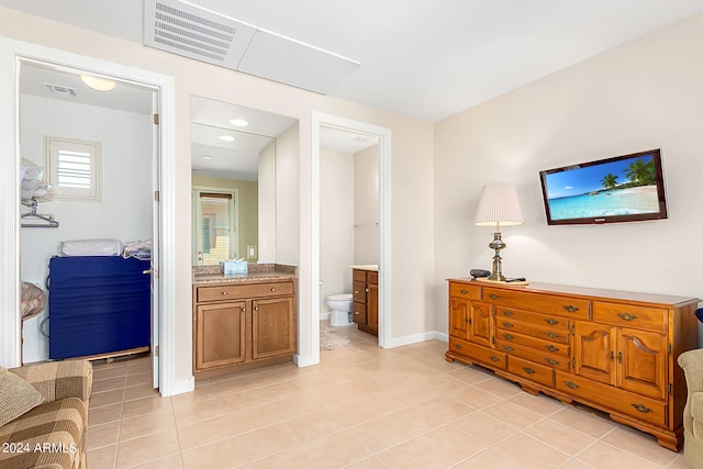 interior space featuring light tile patterned floors and ensuite bathroom