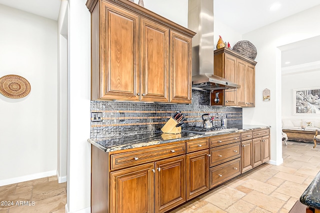 kitchen with stainless steel gas cooktop, ventilation hood, decorative backsplash, and dark stone counters