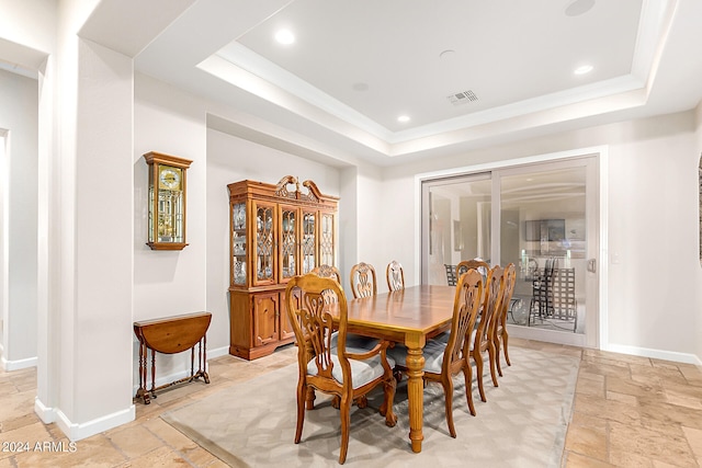 dining space with a raised ceiling