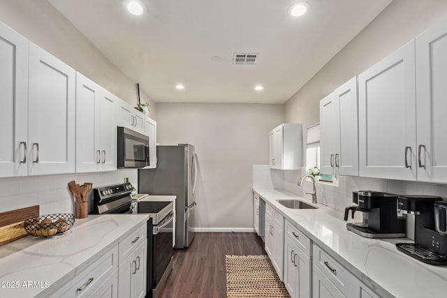 6814 N 59th Ave, Glendale, AZ 85301 - kitchen with appliances with stainless steel finishes, a sink, decorative backsplash, light stone counters, and recessed lighting