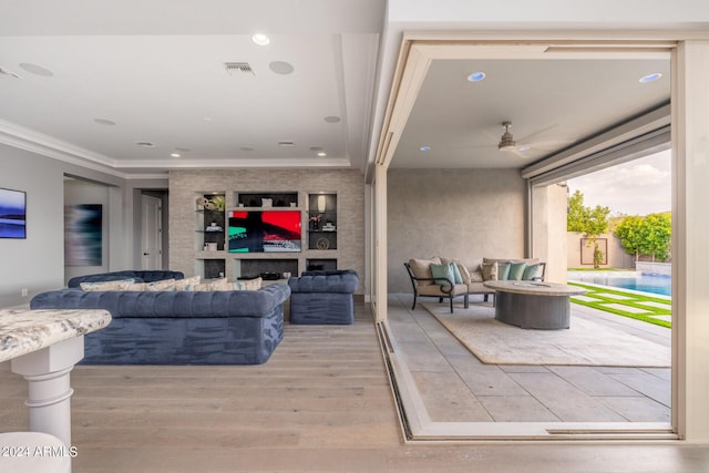 living room featuring ornamental molding, hardwood / wood-style flooring, and ceiling fan