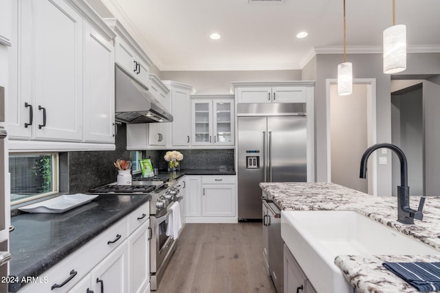 kitchen with white cabinetry, sink, high end appliances, and light hardwood / wood-style flooring