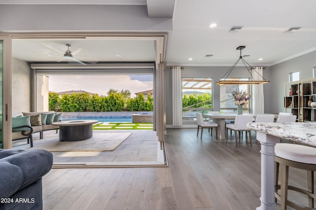 interior space featuring ornamental molding, hardwood / wood-style flooring, and ceiling fan