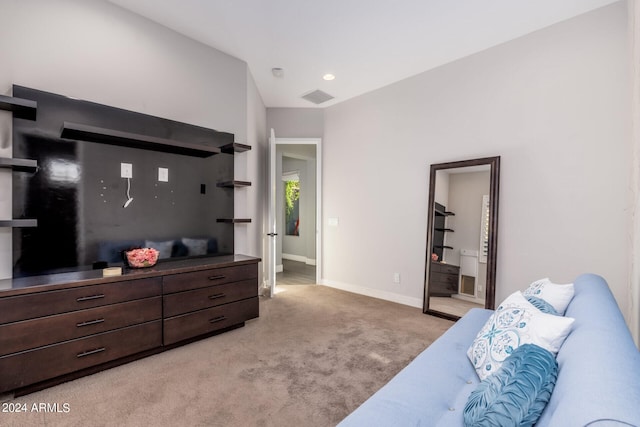 bedroom with light colored carpet, connected bathroom, and vaulted ceiling