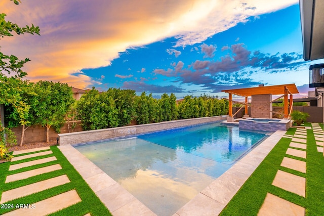 pool at dusk with an in ground hot tub