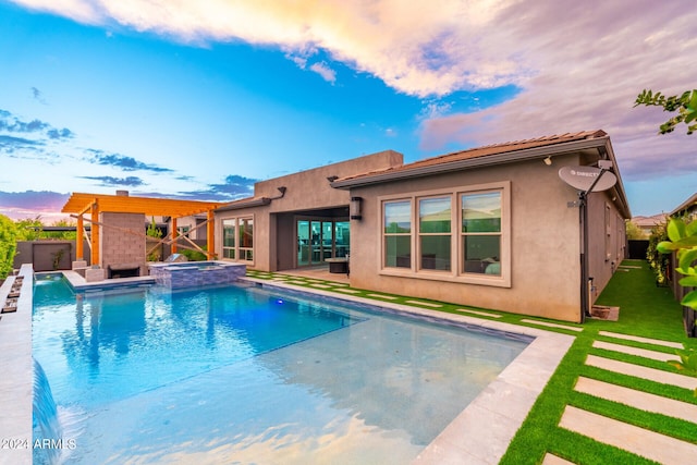 pool at dusk featuring a yard, a patio, and an in ground hot tub