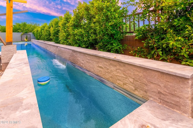 pool at dusk with pool water feature