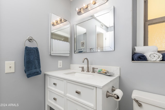 bathroom featuring vanity and toilet