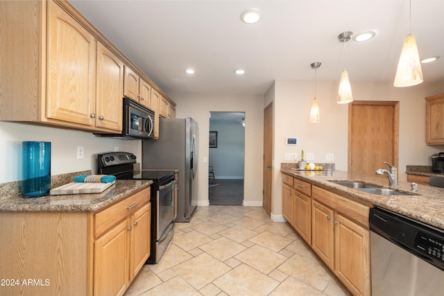 kitchen featuring decorative light fixtures, stainless steel appliances, dark stone countertops, and sink