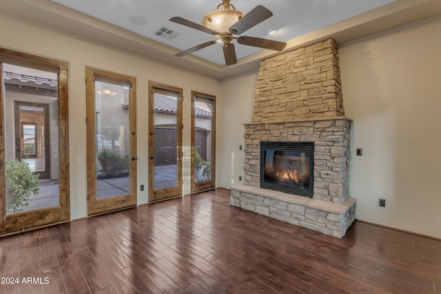 unfurnished living room featuring dark hardwood / wood-style flooring, ceiling fan, a fireplace, and french doors