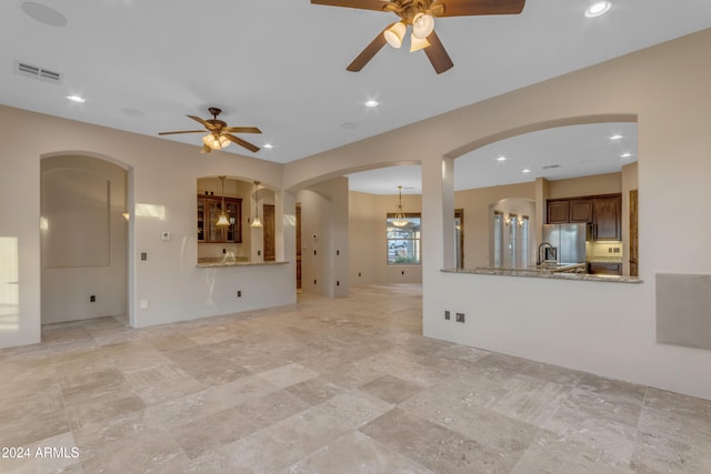 unfurnished living room with ceiling fan and sink