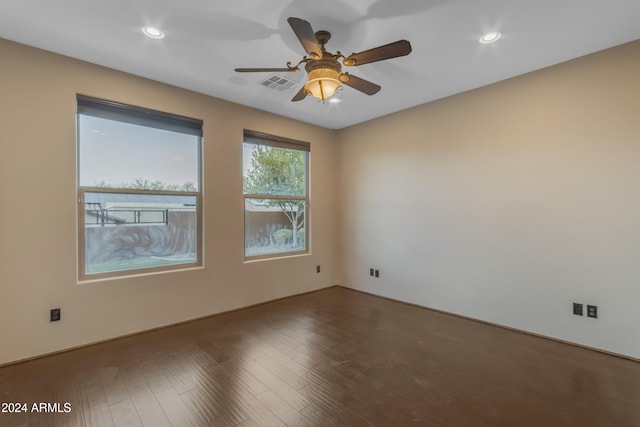 unfurnished room with ceiling fan and dark wood-type flooring