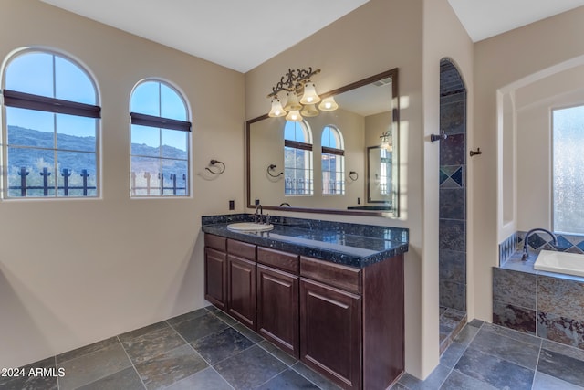 bathroom with a mountain view, vanity, and tiled bath