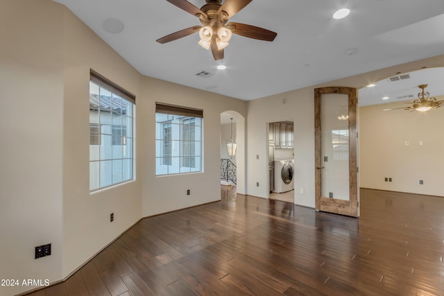 interior space featuring washing machine and dryer, ceiling fan, and dark hardwood / wood-style flooring