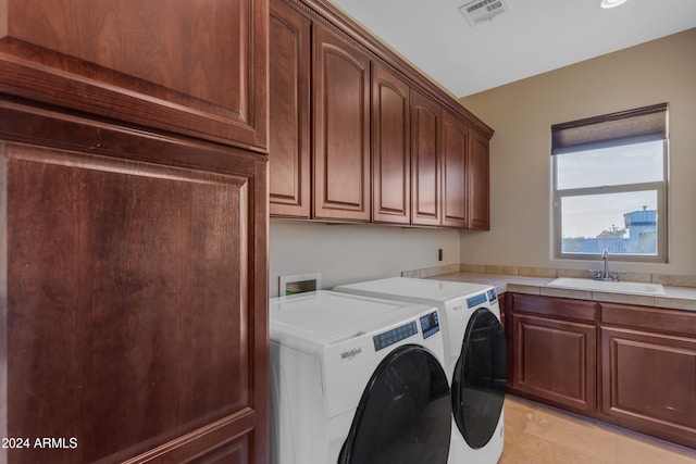 laundry room with washer and dryer, cabinets, and sink