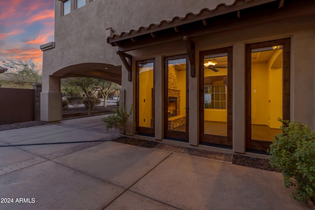 exterior entry at dusk with a patio area