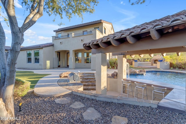 back of property featuring a patio and a balcony