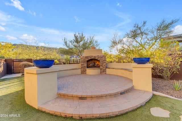 view of patio / terrace featuring an outdoor stone fireplace