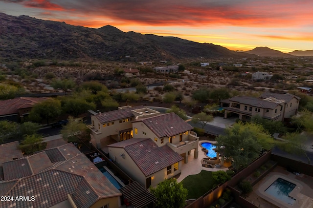 aerial view at dusk featuring a mountain view