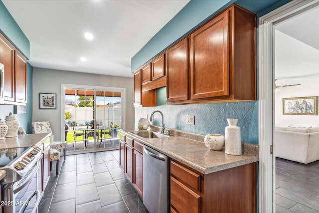 kitchen with sink, decorative backsplash, stainless steel appliances, and dark tile patterned flooring