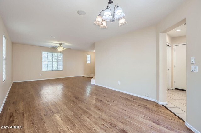 2862 E Megan St, Gilbert, AZ 85295 - spare room featuring wood finished floors, a chandelier, a ceiling fan, and baseboards