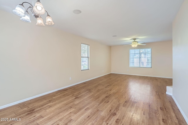 2862 E Megan St, Gilbert, AZ 85295 - empty room featuring a chandelier, healthy amount of natural light, light wood-style floors, and baseboards