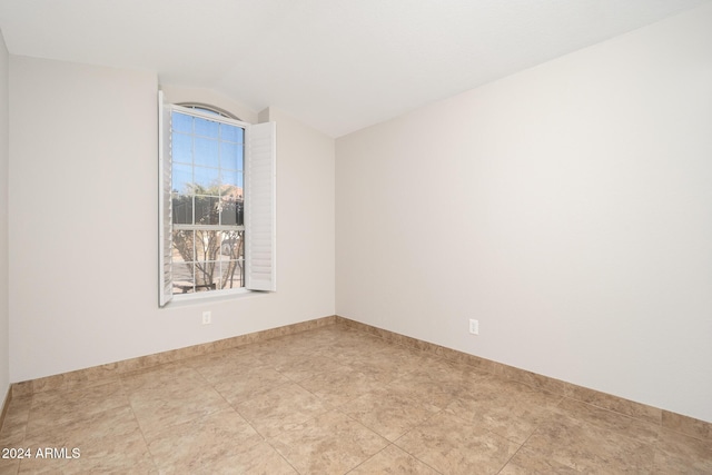 empty room featuring lofted ceiling