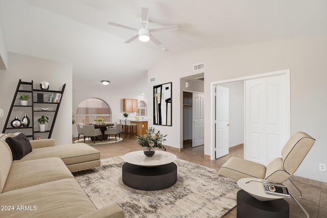 tiled living room with ceiling fan and lofted ceiling