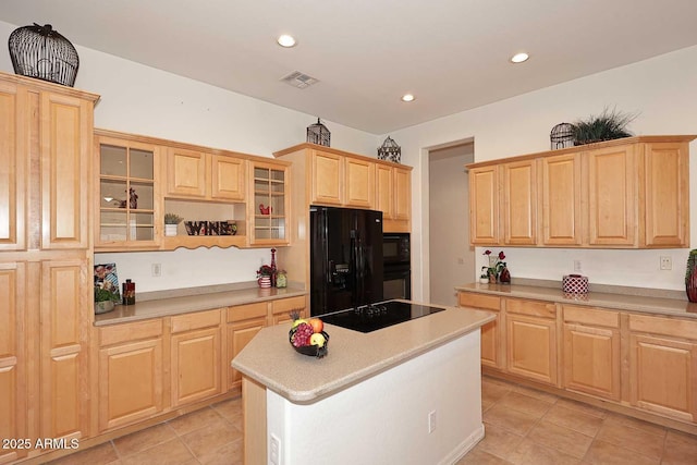 kitchen featuring light tile patterned flooring, light brown cabinets, a center island, and black appliances