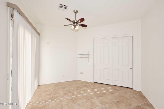 unfurnished bedroom featuring ceiling fan and a closet