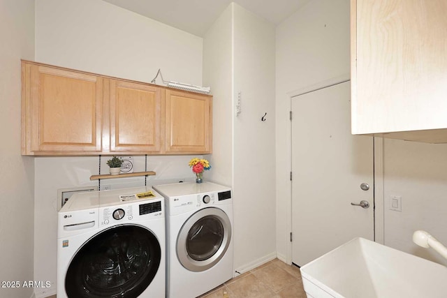 laundry area featuring cabinets, light tile patterned floors, sink, and washing machine and dryer