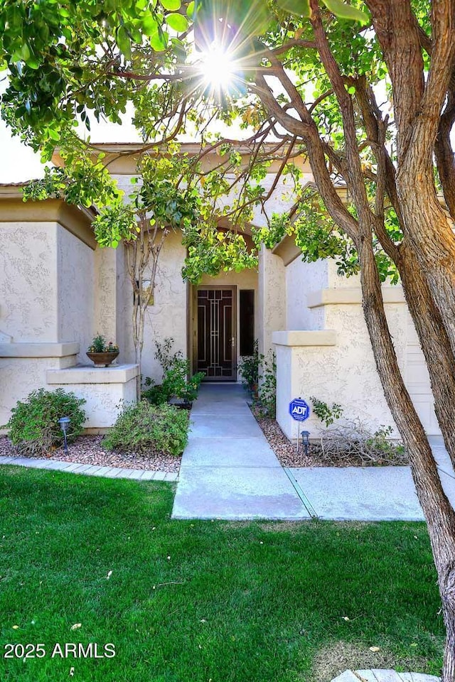 doorway to property with a lawn