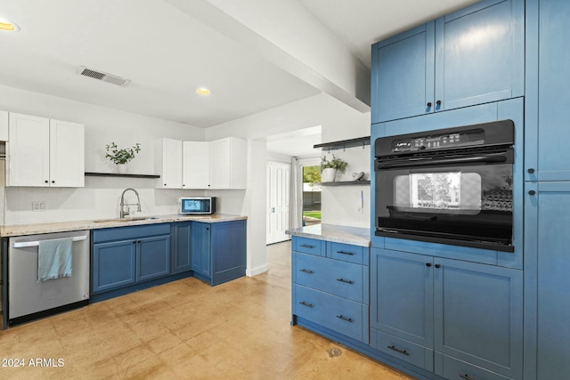 kitchen with white cabinets, sink, blue cabinetry, and stainless steel appliances