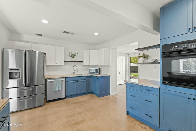 kitchen featuring white cabinets, sink, blue cabinetry, and stainless steel appliances