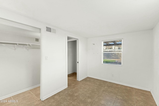 unfurnished bedroom with light tile patterned floors and a closet