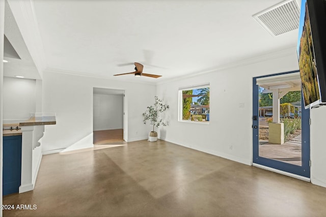 unfurnished living room with ceiling fan, ornamental molding, and concrete floors