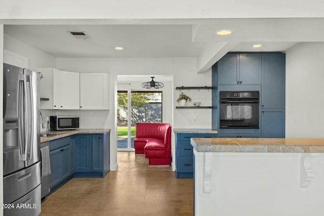 kitchen featuring blue cabinetry, tasteful backsplash, a notable chandelier, white cabinets, and appliances with stainless steel finishes