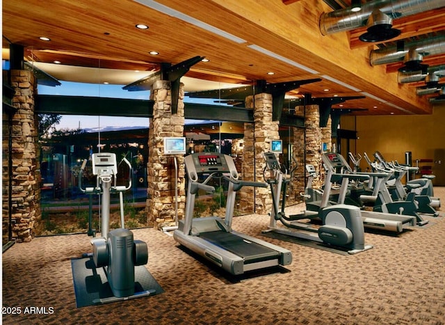 exercise room featuring ornate columns, carpet flooring, and wood ceiling