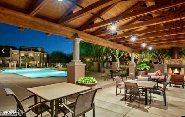 view of patio / terrace with an outdoor fireplace and a community pool