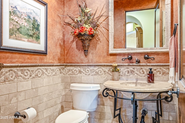 bathroom with tile walls and toilet