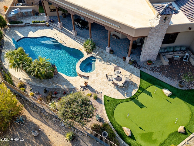 exterior space with an in ground hot tub, a patio, and an outdoor fire pit