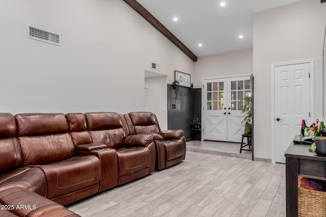 living room with light hardwood / wood-style flooring, high vaulted ceiling, french doors, and beamed ceiling