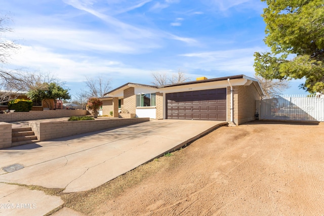 view of front of property featuring driveway, an attached garage, and brick siding