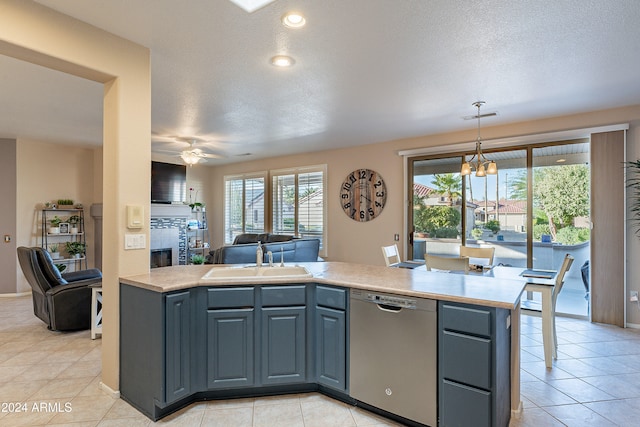 kitchen featuring ceiling fan, sink, stainless steel dishwasher, pendant lighting, and a textured ceiling