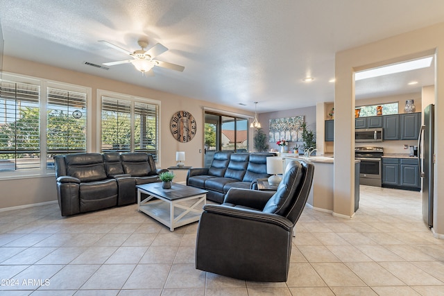 tiled living room with ceiling fan and a textured ceiling