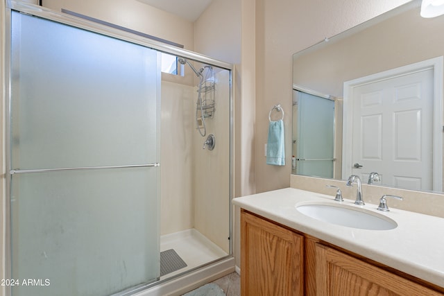 bathroom with vanity and a shower with shower door