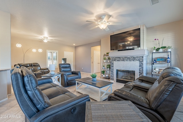 living room with a fireplace, light tile patterned floors, and ceiling fan