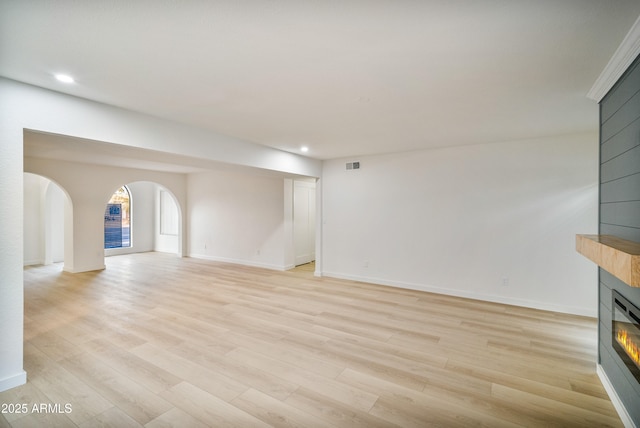 unfurnished living room featuring a fireplace and light hardwood / wood-style floors