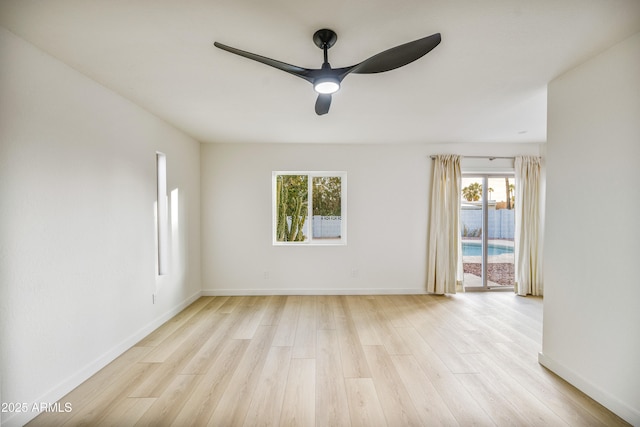 empty room with ceiling fan and light hardwood / wood-style flooring